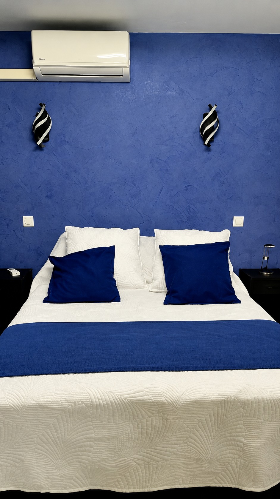 Chambre avec lit double et murs bleus